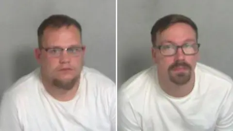 Police mugshots of Ricky Mackmurdie and Ben Barnham. Both have short hair and beards, and they are wearing glasses and white T-shirts.