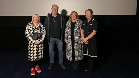 BBC/Ryan Dobney Ashley Dale's mother, Julie, stands next to Elle Edwards' father, Tim, Sam Rimmer's mother, Joanne and Olivia Pratt-Korbel's mother, Cheryl in the cinema at Liverpool One.