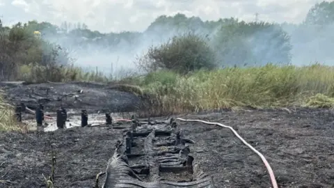 Essex County Fire and Rescue Service A muddy field with large smoke coming out of it 