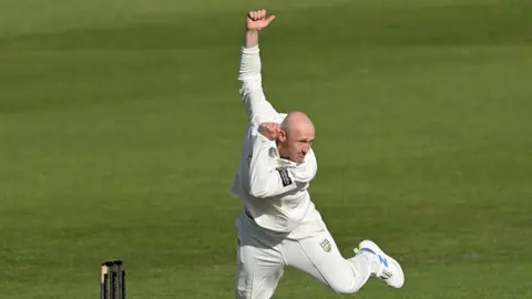 Durham spinner Callum Parkinson in his bowling action.