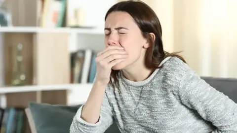 Getty Images Woman feeling sick and holding her mouth and stomach