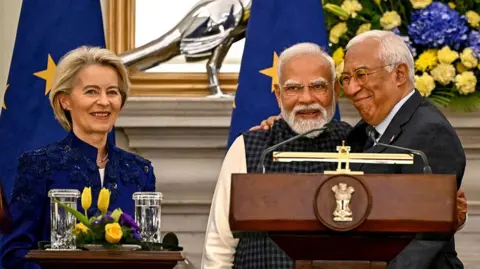 AFP via Getty Images India's Prime Minister Narendra Modi (centre) embraces European Council President Antonio Costa (right) as European Commission President Ursula von der Leyen (left) looks on during the joint press statements after their meeting at the Hyderabad House in New Delhi on 27 January 2026.