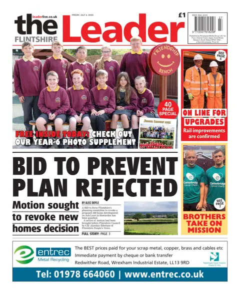 The Flintshire Leader Front page of the Flintshire Leader. Main headline reads: Bid to prevent plan rejected: Motion sought to revoke new homes decision. There is a photo on the top with school children in a maroon uniform. On the right-hand side there is a photo of railworkers in orange uniform, with the headline "on line for upgrades" with the sub-head rail improvements are confirmed, under that is a photo of two men in a aqua-marine t-shirt with the headline "brothers take on mission" 