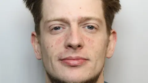 Wiltshire Police A man is staring at the camera in a police mugshot