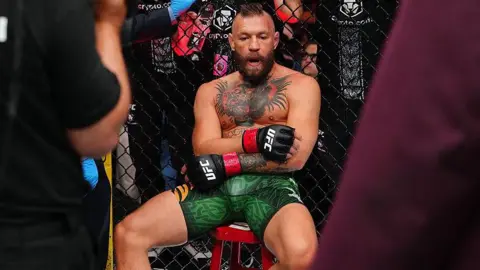 Conor McGregor sits on a stool