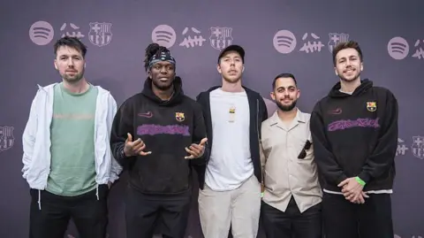 Getty Images Four members of the Sidemen pose with an unknown fifth man in front of a purple background