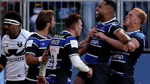 Joe Cokanasiga (second right) holds his arms out in celebration as Bath team-mates jump around him