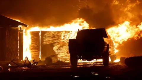 Reuters The Park fire engulfs a building and vehicle near Chico