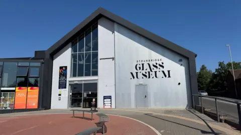 The Glass Museum, in Stourbridge - a modern looking building with glass frontage to the left and grey panelled walls to the right