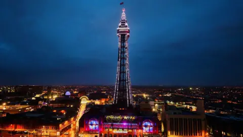 An illuminated Blackpool Tower with a sign highlighting Strictly 2026