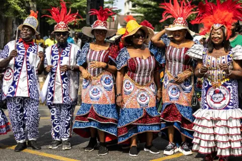 Olympia De Maismont / AFP Rombongan dari Universitas Calabar berpose dengan pakaian yang terbuat dari bahan yang dicetak dengan logo universitas