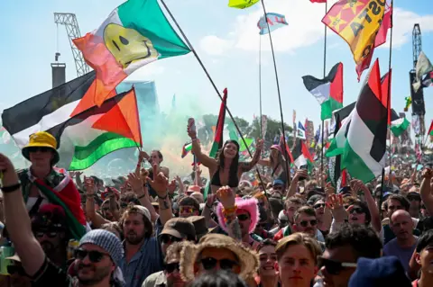 Reuters Fans watch Kneecap, while some hold Palestinian flags