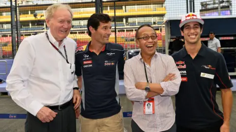 Getty imagens quatro homens de pé lado a lado em frente a uma pista de corrida da F1. Da esquerda para a direita é Ron Walker, Mark Webber, Ong Beng Seng e Daniel Ricciardo