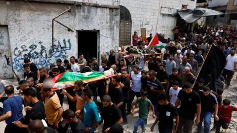 Reuters Mourners carry the bodies of Ayed Abu Hajja (left) and Mohammed Jaber (right) during a funeral in Nur Shams refugee camp, near Tulkarm, in the occupied West Bank (30 August 2024)