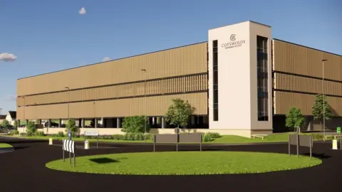 Tewkesbury Borough Council/Robert Hitchins A computer generated artist impression of Cotswolds Designer Outlet's multi-storey car park with a grass covered roundabout in the foreground and the brown five-level car park behind