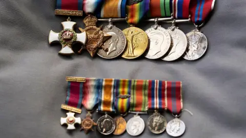 DLI Seven larger war medals in a line above seven smaller ones. All have colourful straps.