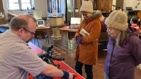 Two women enjoy demonstration of small robot at St. George's Church in Gravesend