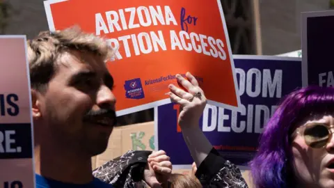 Getty Images Members of Arizona for Abortion Access hold up pro-choice protest signs