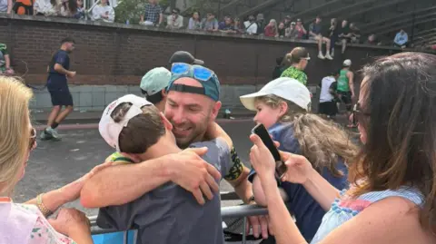 Chris hugs a boy at the barriers in London.
