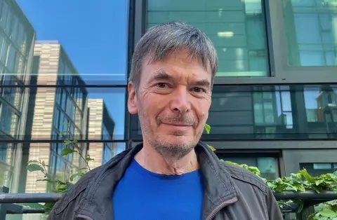 Ian Rankin smiling astatine  the camera extracurricular  immoderate   flats