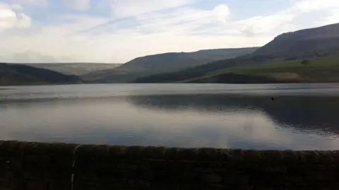 BBC Dovestone Reservoir showing the reservoir with mountains and hills in the background on a clear day.