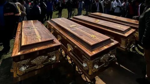 Four coffins lie in a row