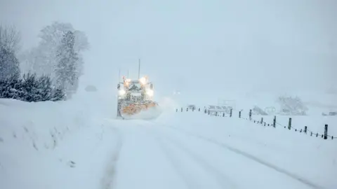 Getty Images a tractor ploughing heavy snow from a road