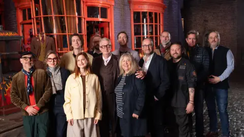 PA Media Actors and behind-the-scenes filmakers of the first Harry Potter film - Harry Potter And The Philosopher's Stone - standing on the set in front of Weasleys' Wizard Wheezes joke shop.