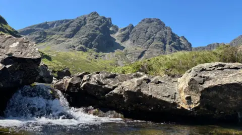 Shaun Slater A view of the Bla Bheinn mountain, with the view looking upwards from a pool of water, which is also visible.