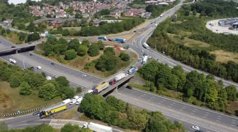 Midlands Connect An aerial view of the flyover roundabout at J28 Pinxton. There is heavy traffic on the roundabout and includes HGVs and cars. 