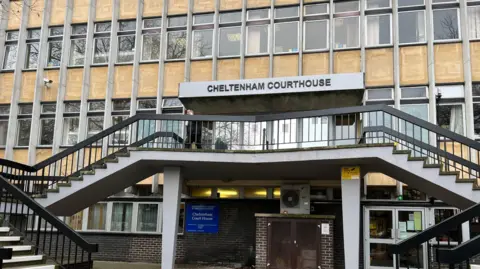 Cheltenham Magistrates Court seen from the outside with steps going up on either side of the main entrance