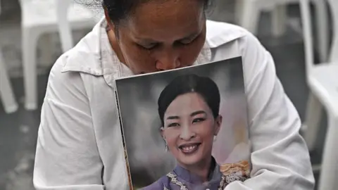 AFP via Getty Images A mourner weeps while holding a photo of Thai princess Bajrakitiyabha Mahidol in front of Chulalongkorn Hospital in Bangkok on June 12, 2026