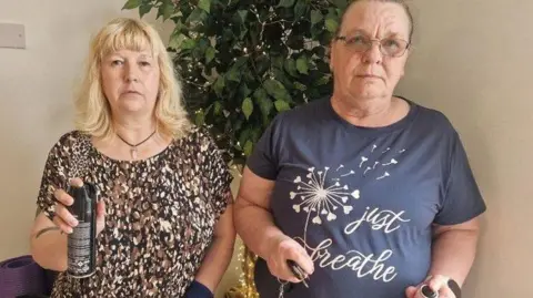 Two women aged in their 50s are holding cans of hairspray and keys that they have been keeping in their handbags.