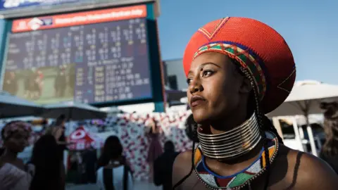 AFP A women looks up at the clock during the 2018 edition of the Vodacom Durban July horse race in Durban, on July 7, 2018