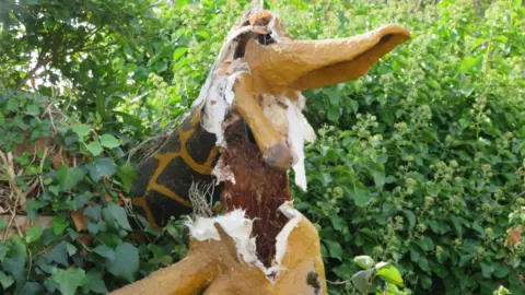 A picture of the destroyed giraffe, which appears to be made of a fibreglass-style material. It is yellow and brown in colour.