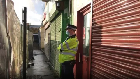 PA Media Police officer outside the Pay and Sleep hostel in The Crescent, Southall