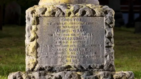 Historic England The monument's inscription bears the names of James Gall and Grace Darling. Many of the letters have worn away and are difficult to read    .