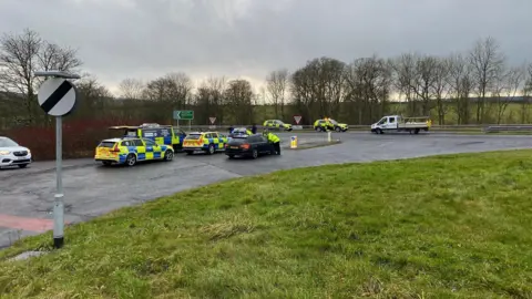 Several emergency vehicles can be seen at a road junction 