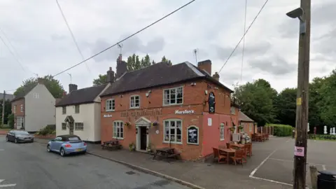 The Crown Inn with two cars at the front and a detached house next to it