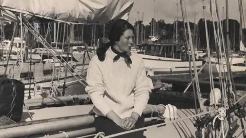 Supplied A black and white photo of Maralyn Bailey sat on a boat. 