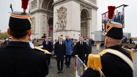 EPA (L-R) France's Minister for the Armed Forces Sebastien Lecornu, Britain's Prime Minister Keir Starmer, France's Prime Minister Michel Barnier and France's President Emmanuel Macron stand at attnetion as they review troops during the commemorations marking the 106th anniversary of the WWI Armistice, in Paris, France, 11 November 2024.