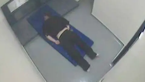PA Thomas Orchard handcuffed and lying face down on a mattress in his cell