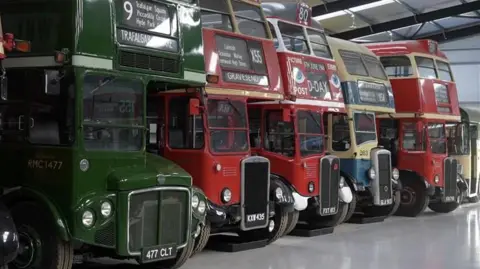 Jamie Niblock/BBC A colourful row of buses inside a building