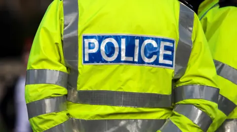 Getty Images Generic image of police officer in yellow hi-vis jacket with the writing police on it.