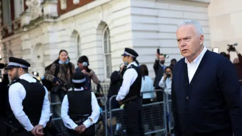 Fotógrafos da Reuters fotografam Edwards atrás de uma barricada quando ele sai do tribunal