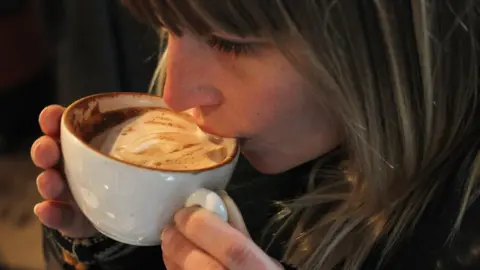 Getty Images Woman drinking a cappuccino in Berlin, 24 Jan 11