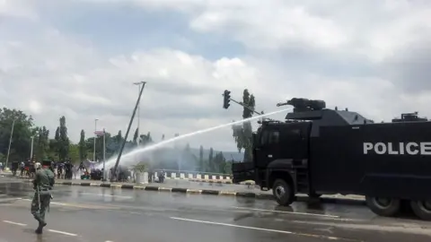 Reuters Police use water cannons to disperse people protesting against alleged brutality by members of Nigeria"s Special Anti-Robbery Squad (SARS), in Abuja, Nigeria October 11, 2020.