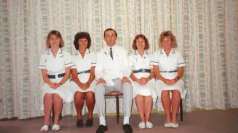 Society of Radiographers Five medical staff are sitting on chairs in front of a curtain.