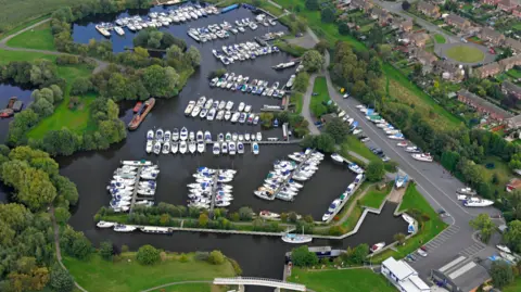 Farndon Marina and Christie and Co An aerial shot of a marina with many boats moored and houses on the left hand side of the image.