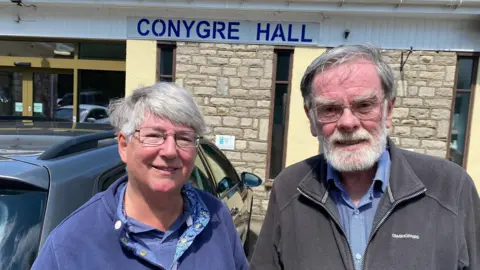 Geraldine and Peter Buchanan in front of Conygre Hall